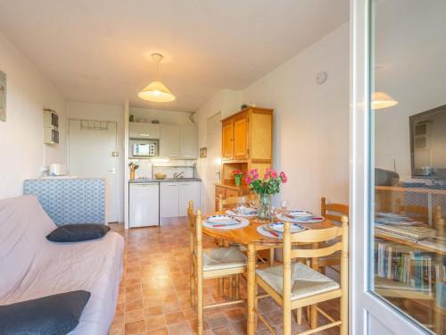uma sala de estar com uma mesa e uma cozinha em Apartment Les Jardins de l'Océan-40 by Interhome em Pontaillac