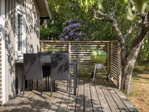 法爾肯貝里的住宿－Chalet Ringsegård Höjden - HAL045 by Interhome，一个带椅子和烧烤炉上一个绿色碗的庭院