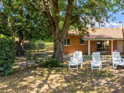 three chairs and a tree in front of a house at Holiday Home La Lette II Albizzias by Interhome in Saint-Julien-en-Born
