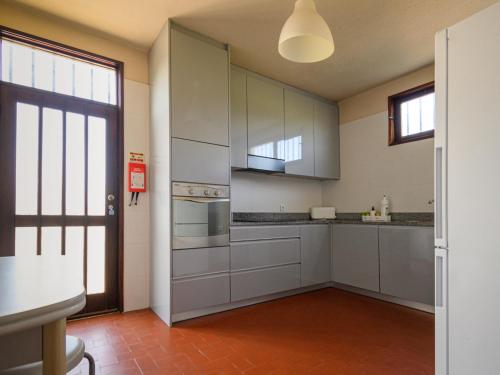 a kitchen with white cabinets and a large window at Holiday Home De Carreço - CRR100 by Interhome in Carreço