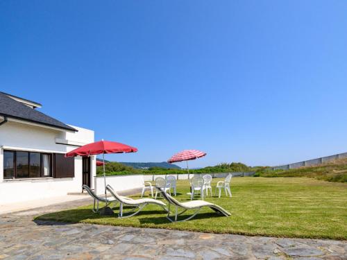 a group of chairs and umbrellas on a lawn at Holiday Home De Carreço - CRR100 by Interhome in Carreço