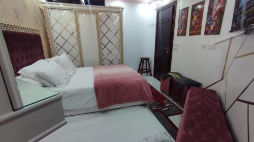 een kleine slaapkamer met een bed en een stoel bij شاليه للايجار بورتو سعيد in Port Said