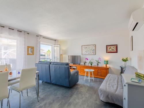 uma sala de estar com um sofá azul e uma mesa em Apartment Royal Marine-4 by Interhome em Fréjus