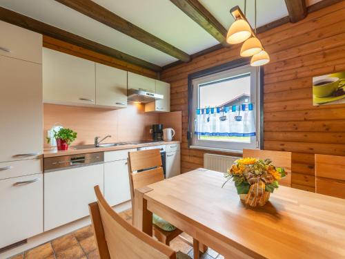 a kitchen with a wooden table with flowers on it at Apartment Am Hohen Bogen-16 by Interhome in Arrach