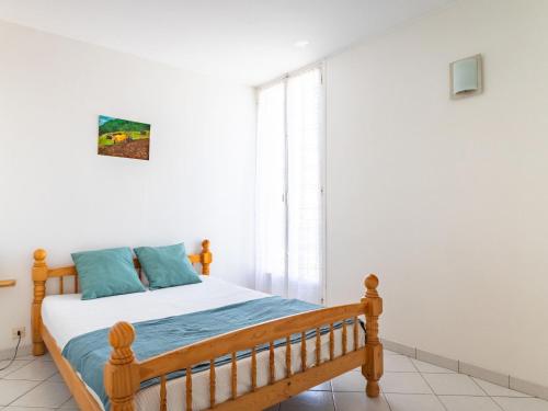 une chambre avec un lit en bois et une fenêtre dans l'établissement Apartment Les Roses Lauriers by Interhome, au Lavandou