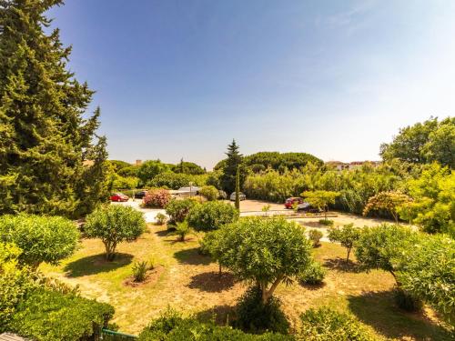 Elle offre une vue sur un jardin avec des arbres et des buissons. dans l'établissement Apartment Les Roses Lauriers by Interhome, au Lavandou