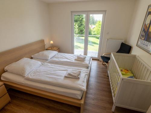 a bedroom with a bed and a crib and a window at Holiday Home Schwarzwald by Interhome in Dittishausen