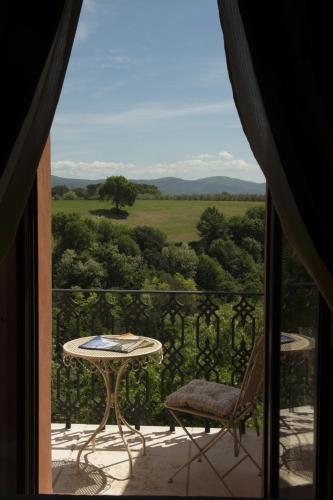 a balcony with a table and a chair and a view at Palazzo Pacini in Colle Val D'Elsa