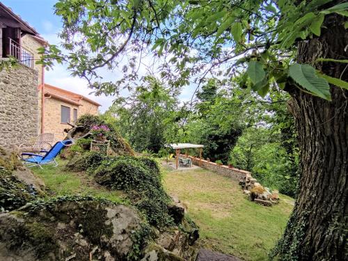 a yard with a blue chair and a house at Holiday Home Turi by Interhome in Roccatederighi