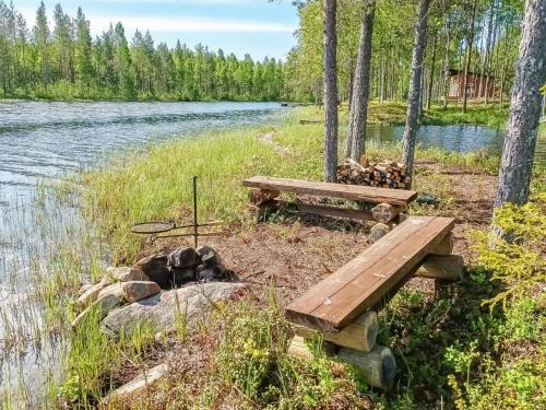 una mesa de picnic y una hoguera junto a un río en Holiday Home Jolmalompolo by Interhome, en Raanujärvi
