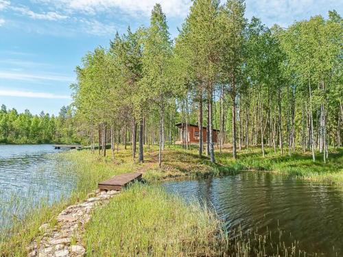 uma cabana na floresta ao lado de um lago em Holiday Home Jolmalompolo by Interhome em Raanujärvi