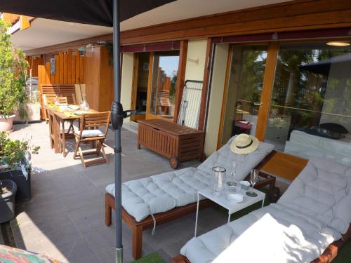 un patio con un sofá blanco y una sombrilla en Apartment Résidence Byblos 11 by Interhome, en Crans-Montana