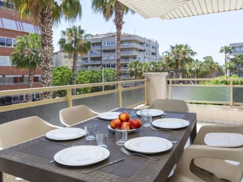 - une table avec des assiettes et des fruits sur le balcon dans l'établissement Apartment Jardines Family-4 by Interhome, à Salou