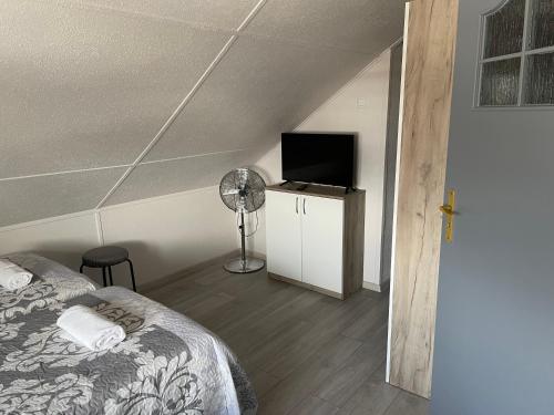 a bedroom with a bed and a flat screen tv at Willa Anna in Gródek Nad Dunajcem
