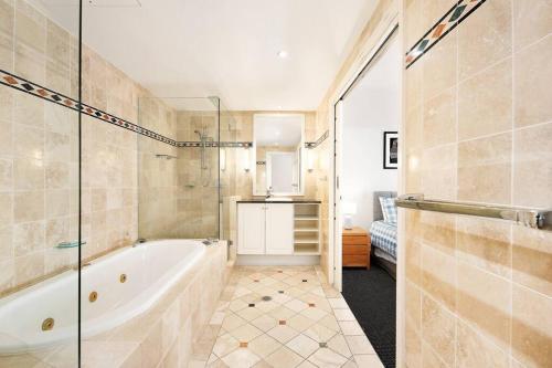 La salle de bains est pourvue d'une baignoire et d'un lavabo. dans l'établissement Noosa Beachside Apartment, à Noosa Heads