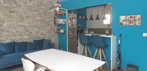 マルセイユにあるMaison bord de merのリビングルーム(青いソファ、白いテーブル付)