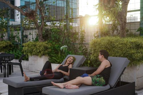 a man and woman sitting in chairs in a courtyard at Crowne Plaza Bandung by IHG in Bandung