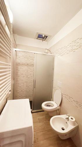 a white bathroom with a toilet and a sink at CASA EMMA in Chioggia
