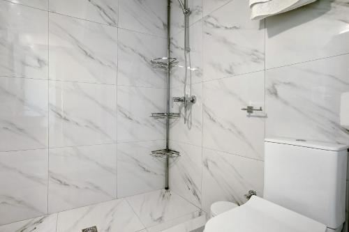 a white bathroom with a shower with a toilet at Villa Drosia in Volimes