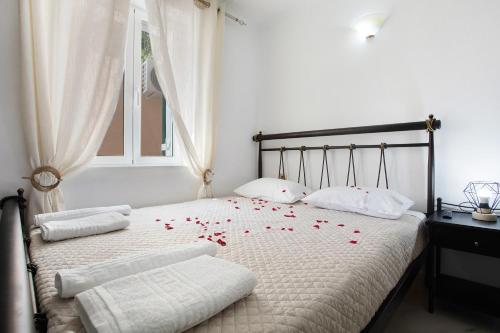 a bedroom with a bed with red roses on it at Villa Drosia in Volimes