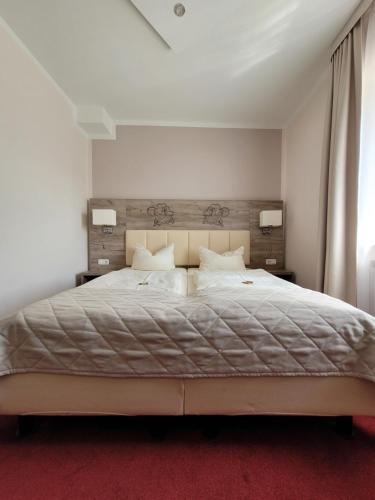 a bedroom with a large bed and a red carpet at Hotel Rosengarten in Bad Salzuflen