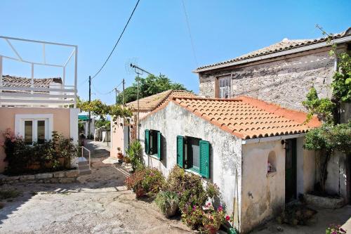 a group of houses with green shutters on a street at Villa Drosia in Volimes