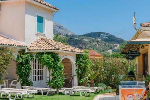 ein Haus mit Picknicktischen davor in der Unterkunft Valentino Corfu in Ýpsos