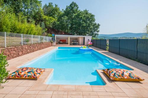 une piscine avec deux oreillers dans une cour arrière dans l'établissement Les Roses d'Angelina - Superbe maison avec piscine, à Montlaur