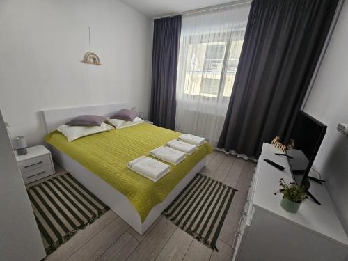 a small bedroom with a bed with a green blanket at Summer Crib Mamaia-Sat in Mamaia Nord