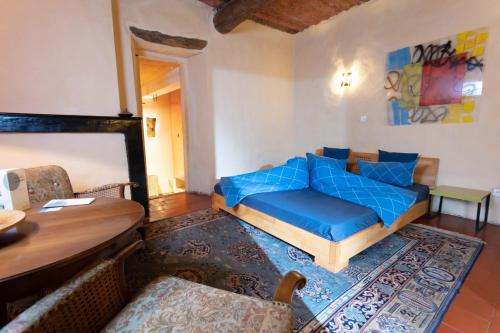 - un salon avec un canapé bleu et une table dans l'établissement La Vieille Maison - Halte Gourmande, à Durfort-et-Saint-Martin-de-Sossenac