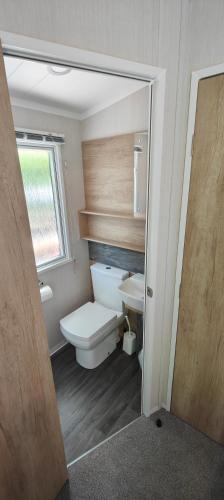 a bathroom with a toilet and a sink at Aberdunant Hall Holiday Park in Porthmadog
