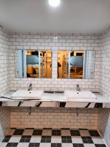 two sinks in a bathroom with two mirrors at Grand Beach Resort in Ko Tao