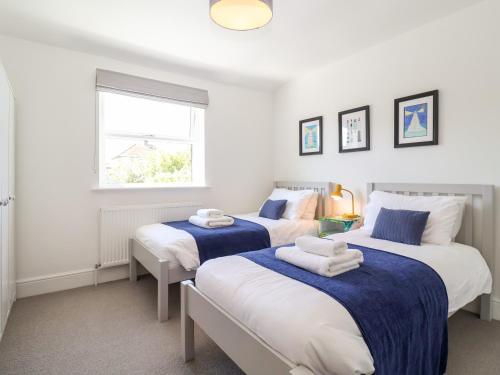 two beds in a bedroom with blue and white at Long View in Southwold