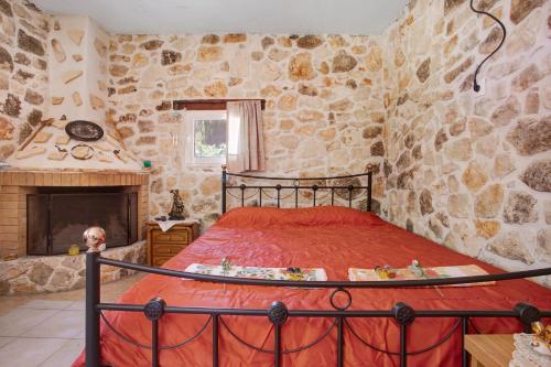 a bedroom with a bed and a stone wall at Lithahiro stone house in Keri