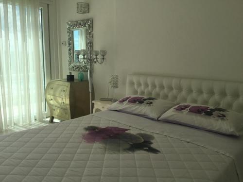 una camera con un grande letto, un comò e uno specchio di Suite Luxury Seaview a Misano Adriatico