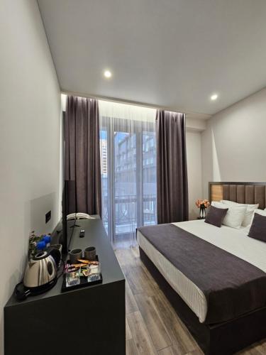 a hotel room with a bed and a desk with at Orion ApartHotel in Yerevan