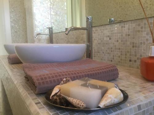 a bathroom with a sink and a candle on a counter at Suite Luxury Seaview in Misano Adriatico