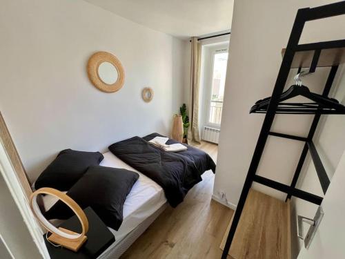 une chambre avec un lit avec des oreillers noirs et une échelle dans l'établissement La Maison Cosy Paris Centre - Métro - Wifi, au Kremlin-Bicêtre