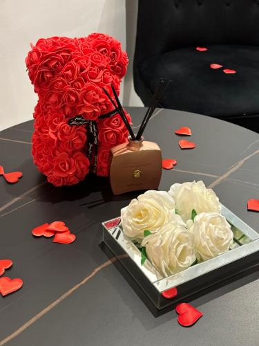 Un mazzo di rose rosse e una borsa su un tavolo di Suite de prestige avec spa & cinéma a Ivry-sur-Seine