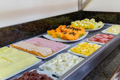 a buffet of different types of cheeses and meats at Hotel Dom Rafael Premium in Santa Maria