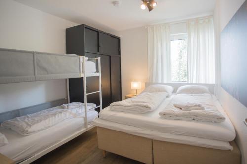 ヴィンターベルクにあるAppartement Brink Fichtenweg 43のベッドルーム1室(二段ベッド2台、窓付)が備わります。