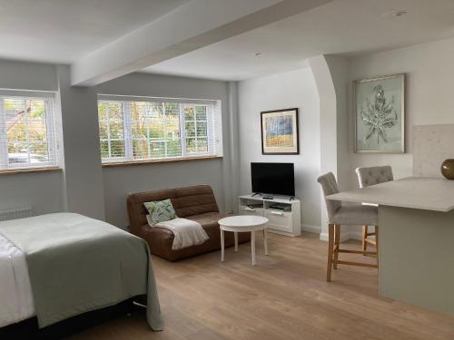 a bedroom with a bed and a couch and a table at Yew Tree House in Woodstock