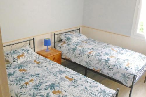 un dormitorio con 2 camas y una lámpara azul en una mesita de noche en F4 VERNET LES BAINS en Vernet-les-Bains