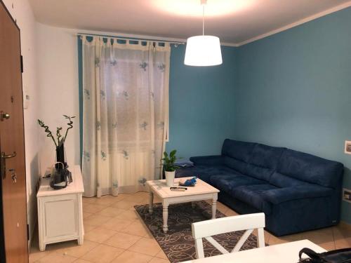 sala de estar con sofá azul y mesa en Appartamento Giulia, en Muravera