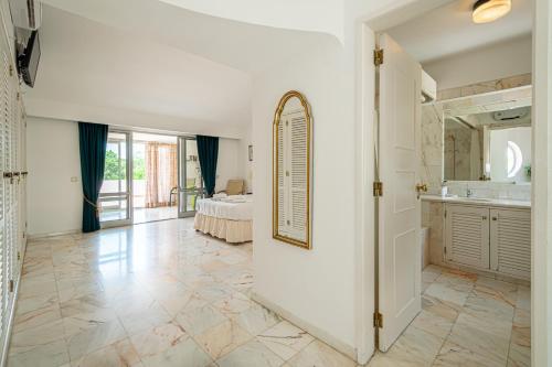 Großes Zimmer mit einem Bad mit einem Bett und einem Spiegel. in der Unterkunft BeGuest Vale de Lobo 932 Villa in Almancil