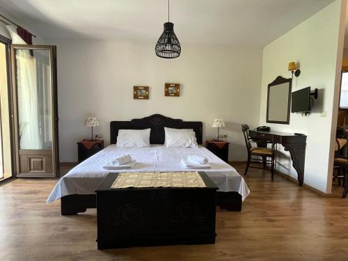 1 dormitorio con 1 cama grande y 1 mesa en Archontiko Zachou, en Loutrá Vólvis