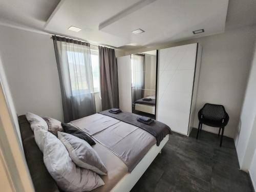 1 dormitorio con 1 cama grande y espejo en Villa Capris apartments, en Koper