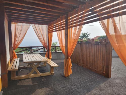 a balcony with an orange curtain and a bench at Lucy's Rosegarden in Urzelina