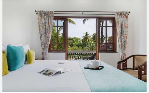 a bedroom with a bed with a view of the ocean at Anthy’s à la Campagne in Benaulim