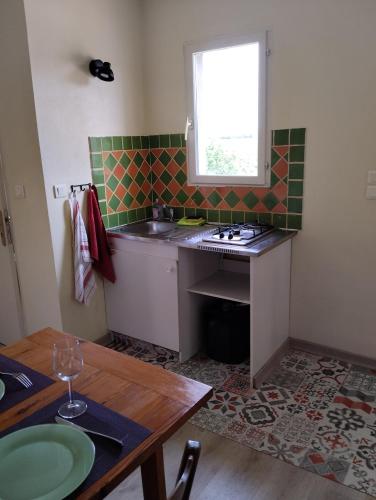 une petite cuisine avec un évier et une table dans l'établissement Studio calme dans les vignes avec piscine, à Suze-la-Rousse